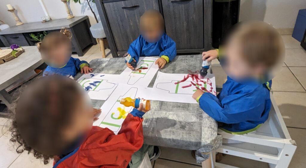 des enfants chez leur assistante maternelle qui font de la peinture