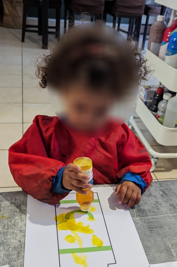 des enfants chez leur assistante maternelle qui font de la peinture