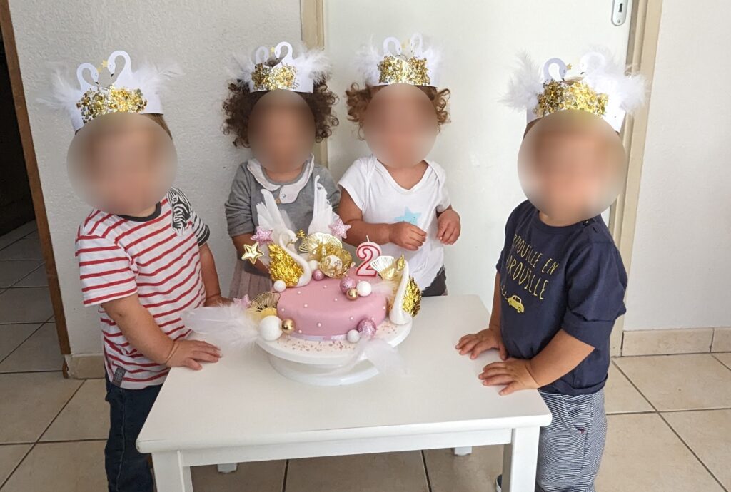 enfants chez nounou devant un gâteau d'anniversaire