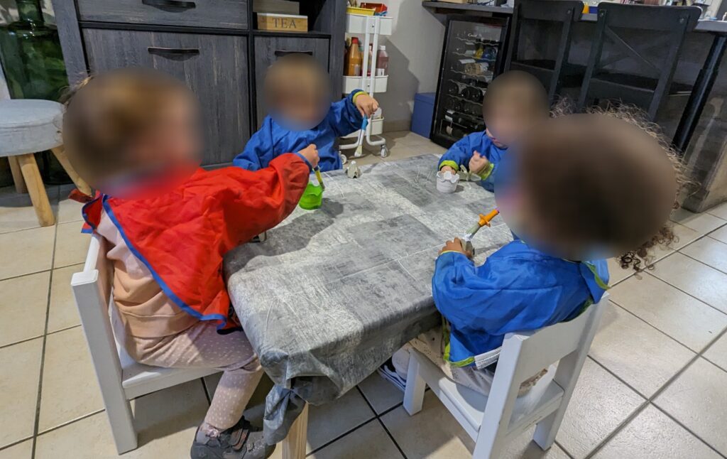 Des enfants chez l'assistante maternelle qui font de la peinture