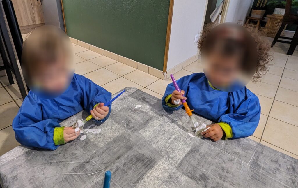 Des enfants chez l'assistante maternelle qui font de la peinture